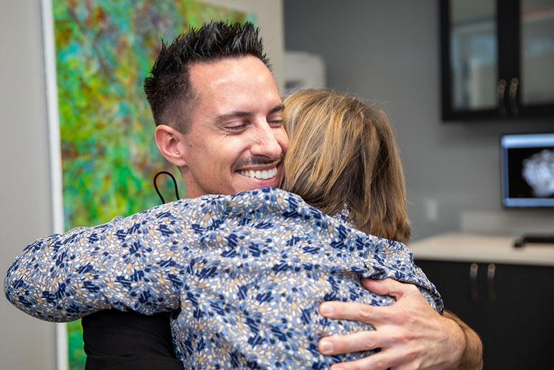 Dr. Chambers hugging dental patient