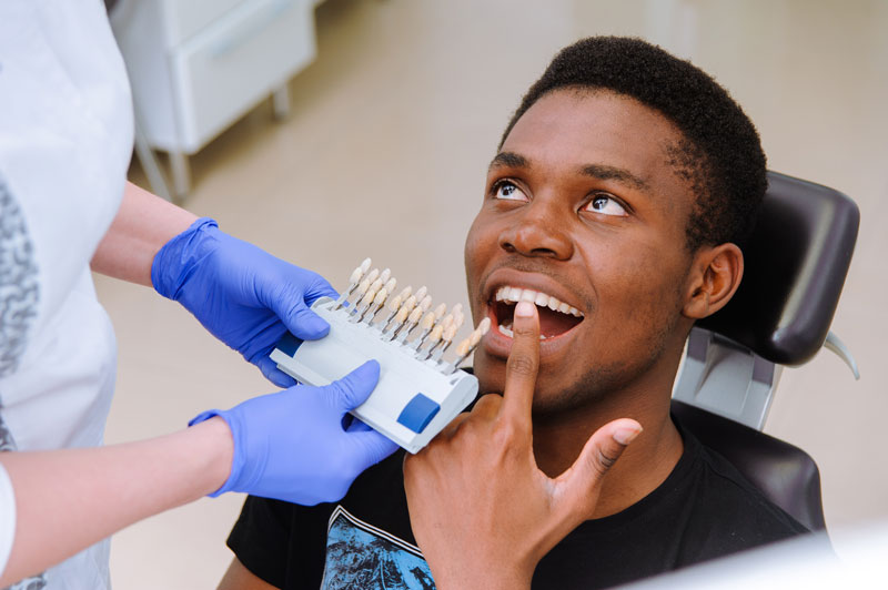Dental patient pointing to teeth as the dentist makes the process of treatment in dental clinic.