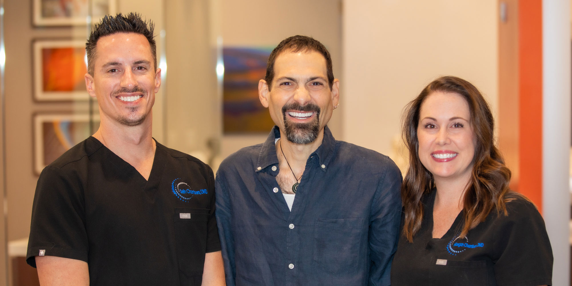 chris a patient at bluegrass dentistry smiling with 2 of the doctors nearby