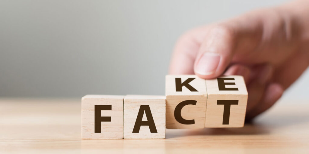 Dental Patient Holding Fact vs Fake Sign Blocks