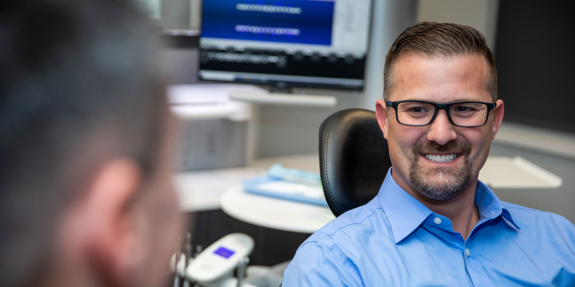 john a patient at bluegrass dentistry smiling at the doctor after receiving his new teeth
