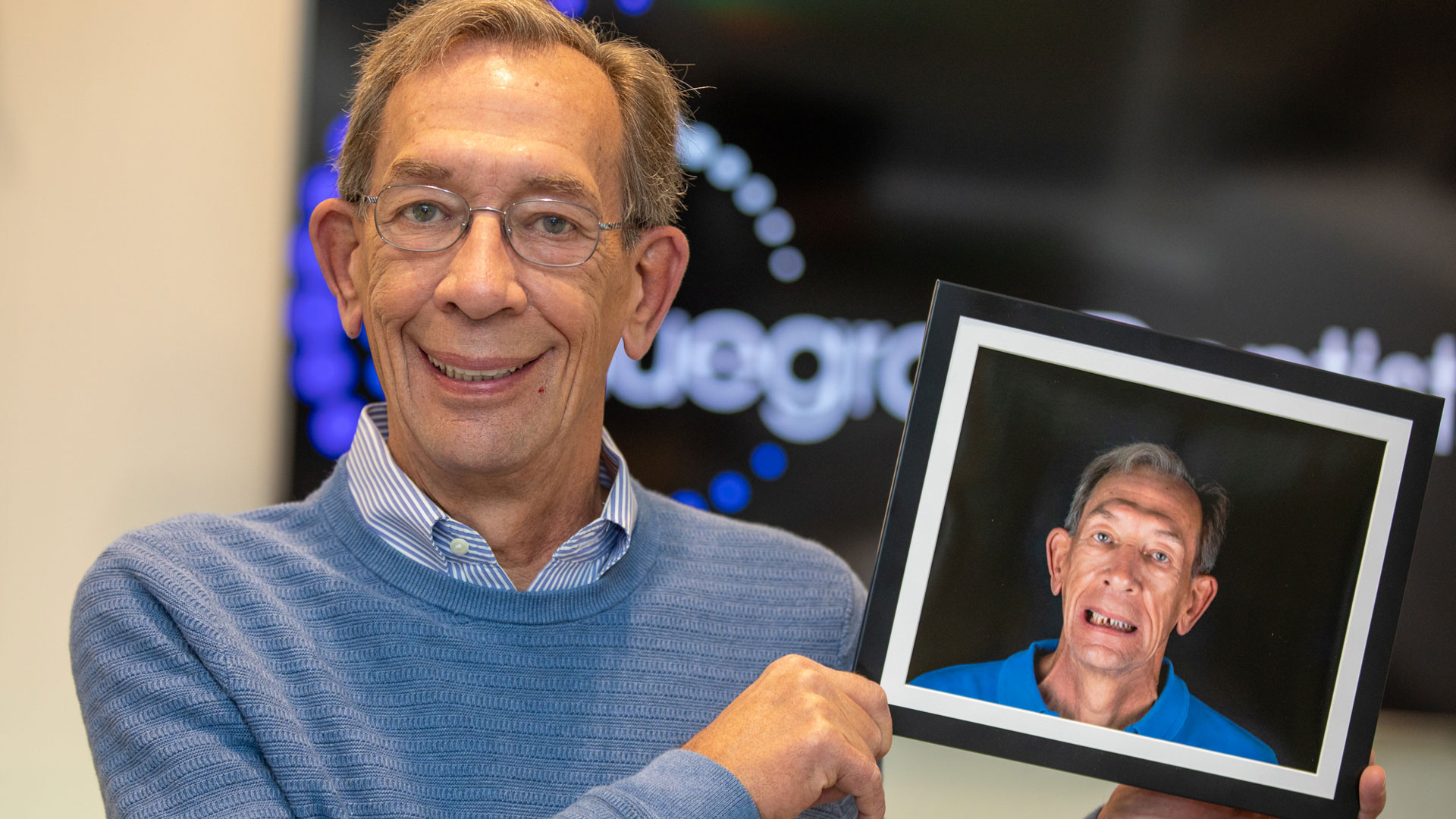 ray holding up a photo of him before he got his teeth repaired at bluegrass dentistry